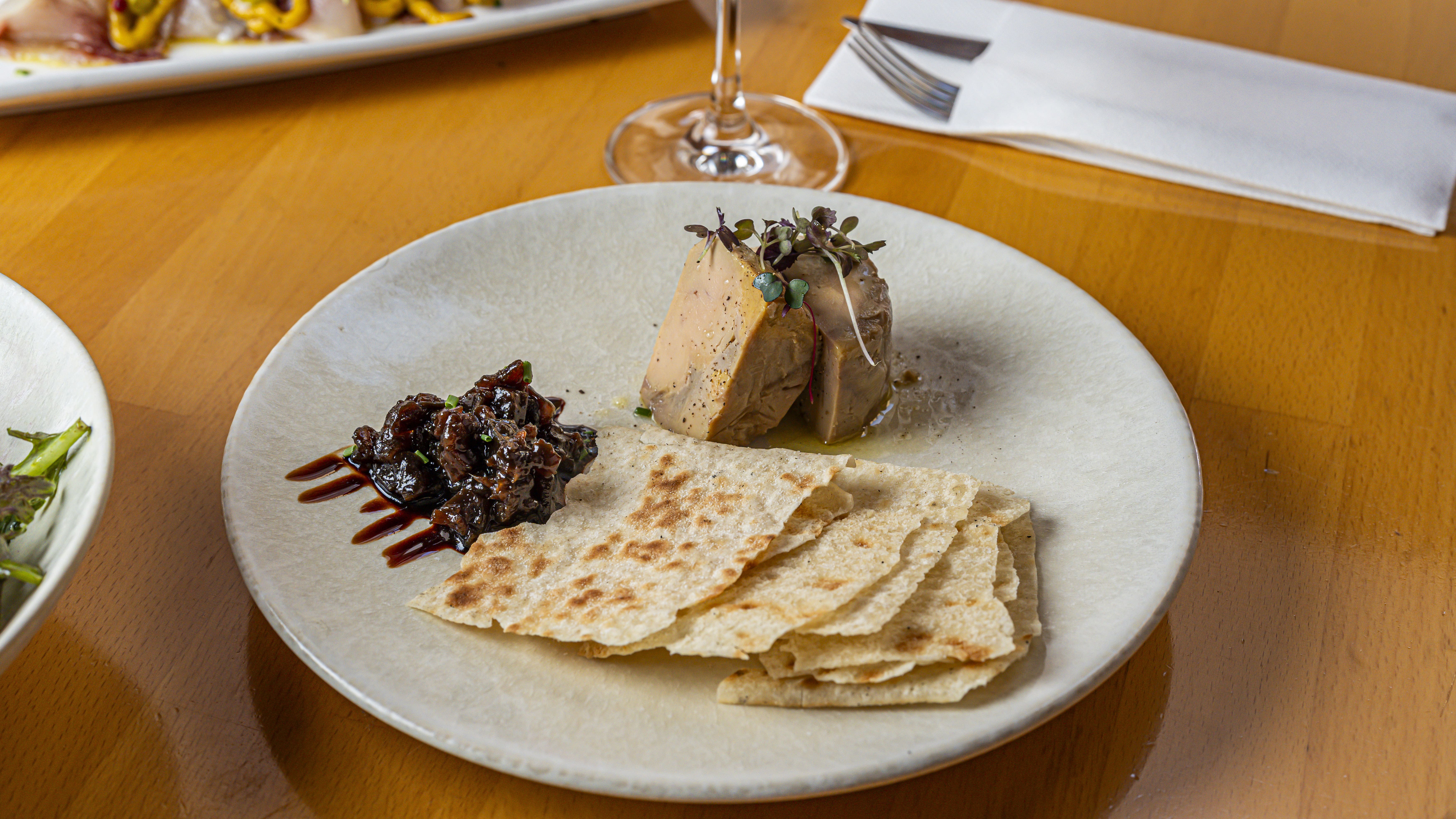 Platillo de Foie de Villamartín de Campos a la sal y confitura de berenjena y regaliz servido en Més de Vi, restaurante de platillos en Poblenou Barcelona
