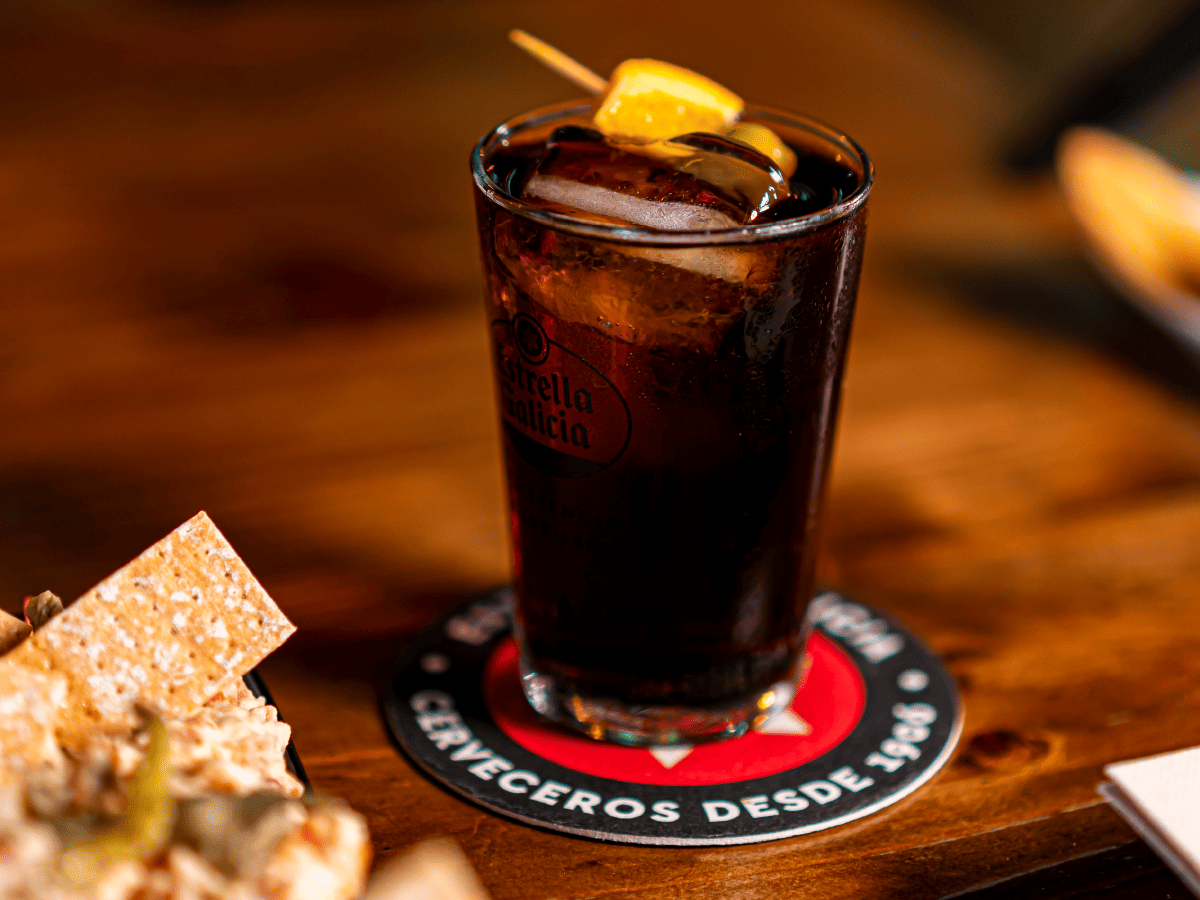 Glass of red vermouth with ice and orange served with an aperitif